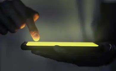 mao-tocando-a-tela-iluminada-do-smartphone (1)