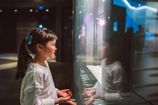 Lovely cheerful girl checking out exhibits in gallery.