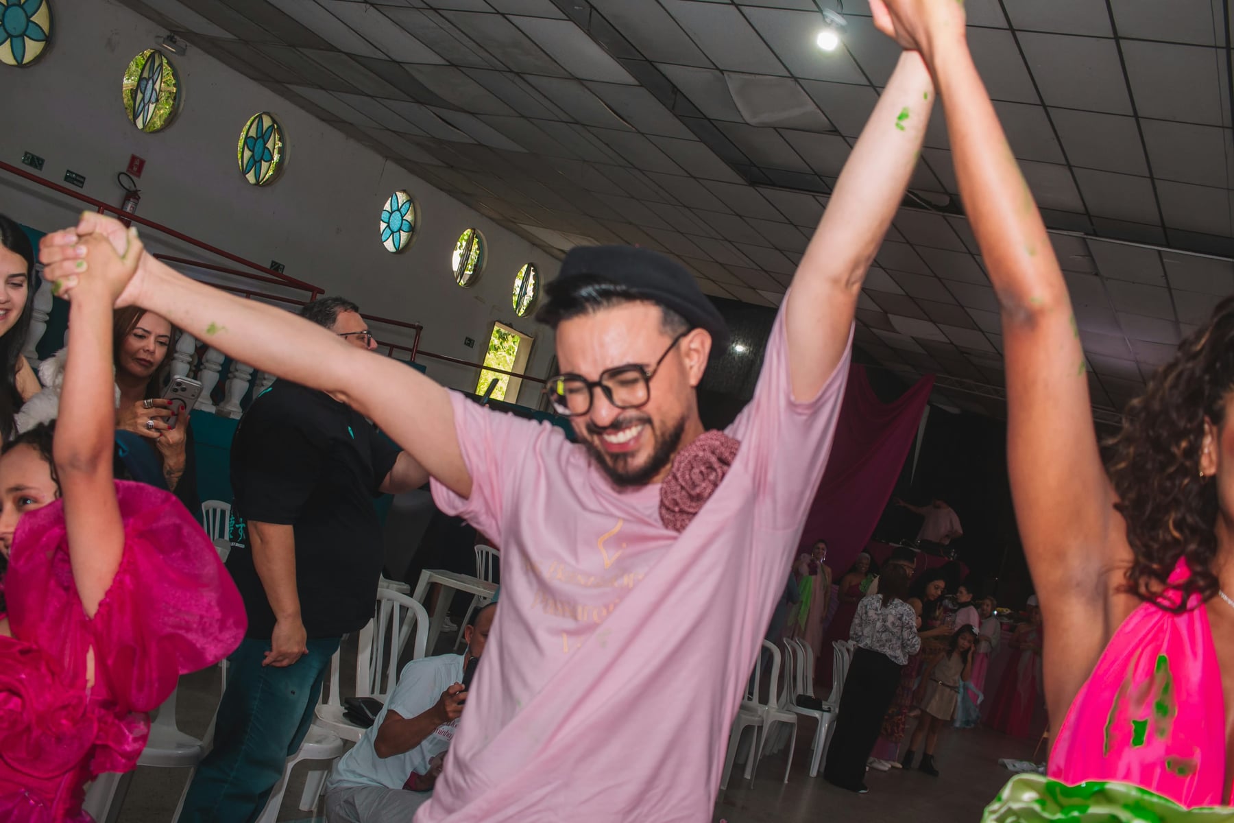 William Malagres dança de braços erguidos com participantes do desfile